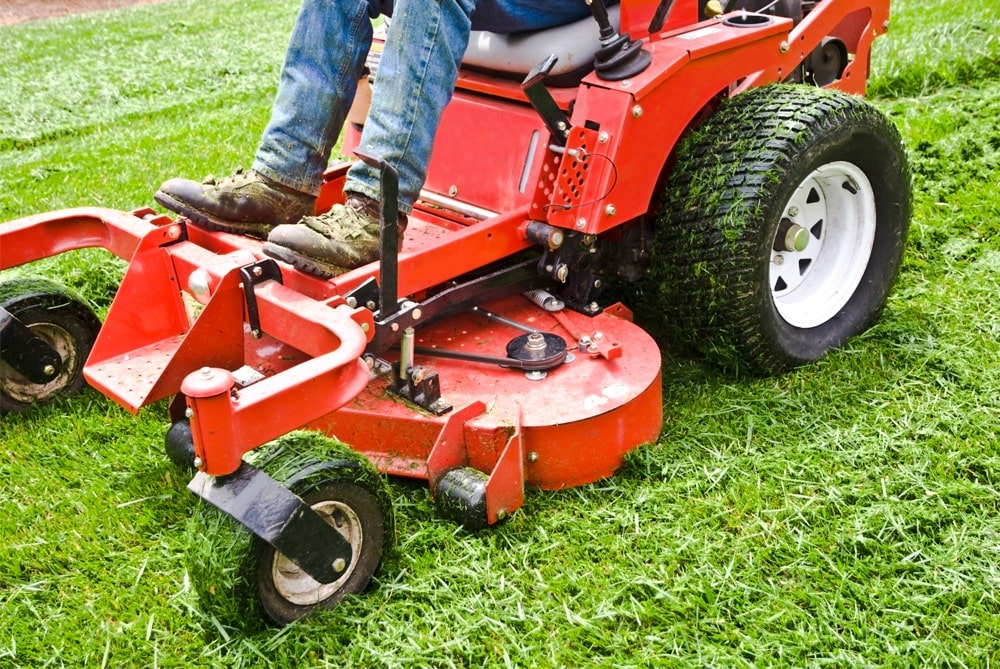 Image of a red commercial mower cutting the grass.