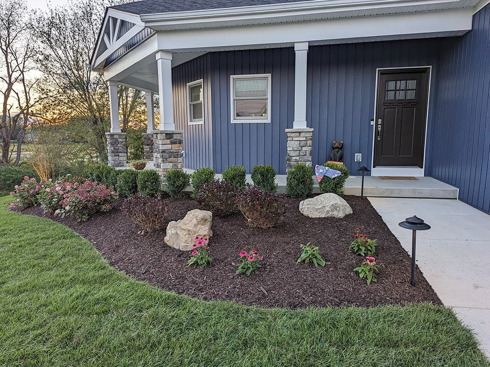 After: Image of the completed project, featuring new sod, shrubbery, flowers, and more, done by BladeRunners Landscaping.