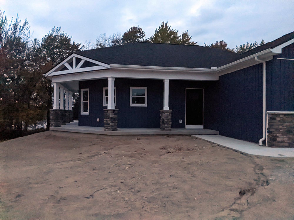 Before: Image of the same home, front walkway view with no sod or landscaping.