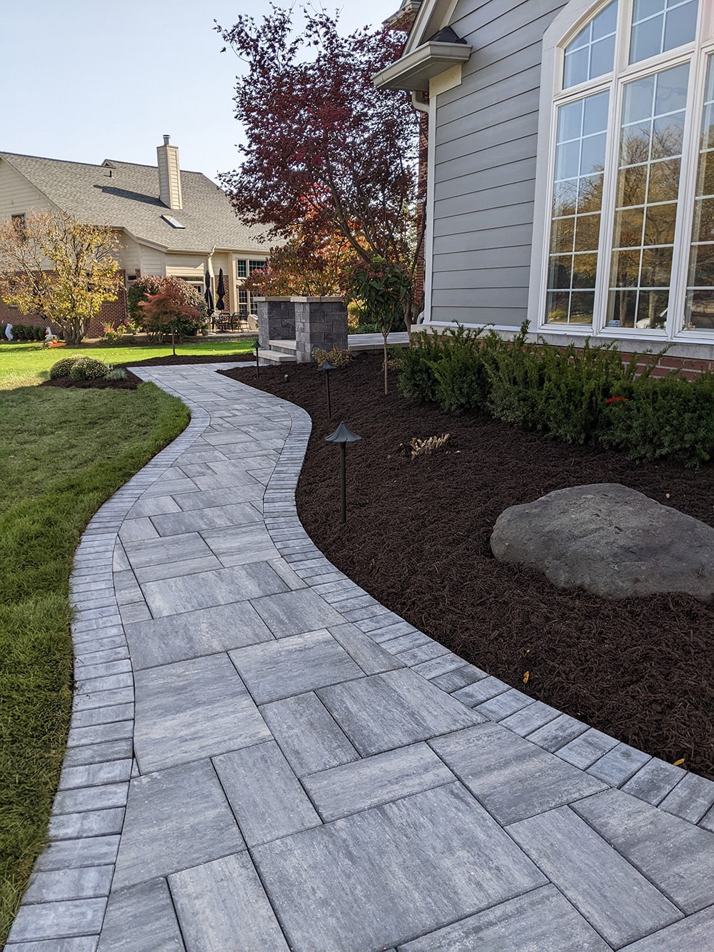 After: Image of the same home with an updated stone walkway, completed by BladeRunners Landscaping.