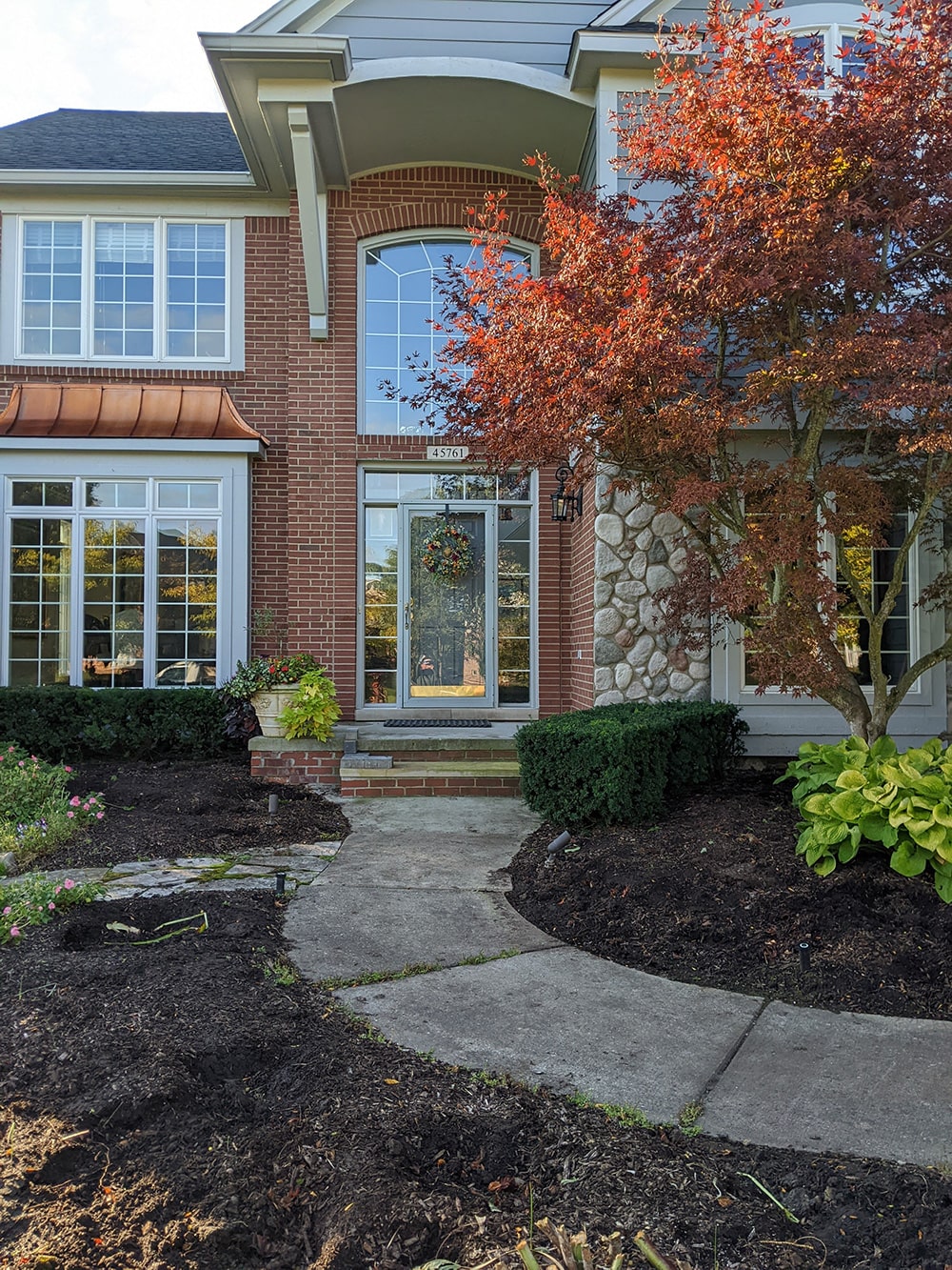 Before: Front-facing image of the same residential home with a drab walkway and steps.