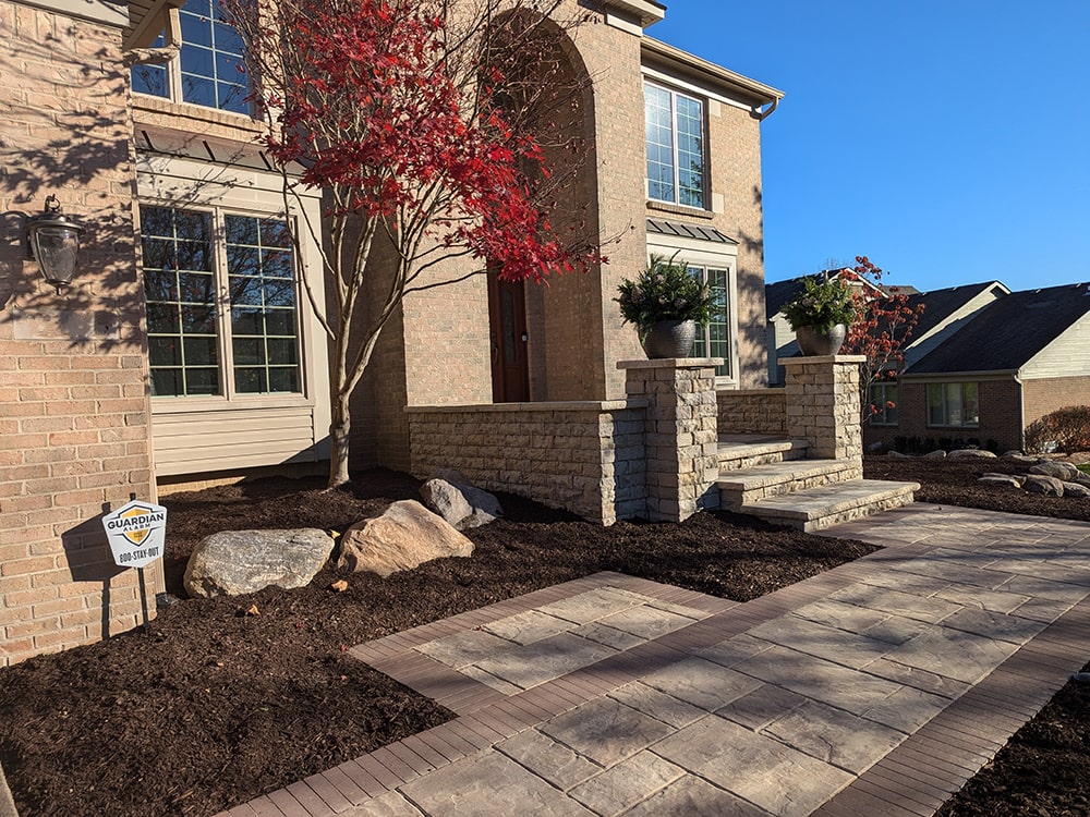 Image of new brick walkway and porch of a residential home, completed by BladeRunners Landscaping.