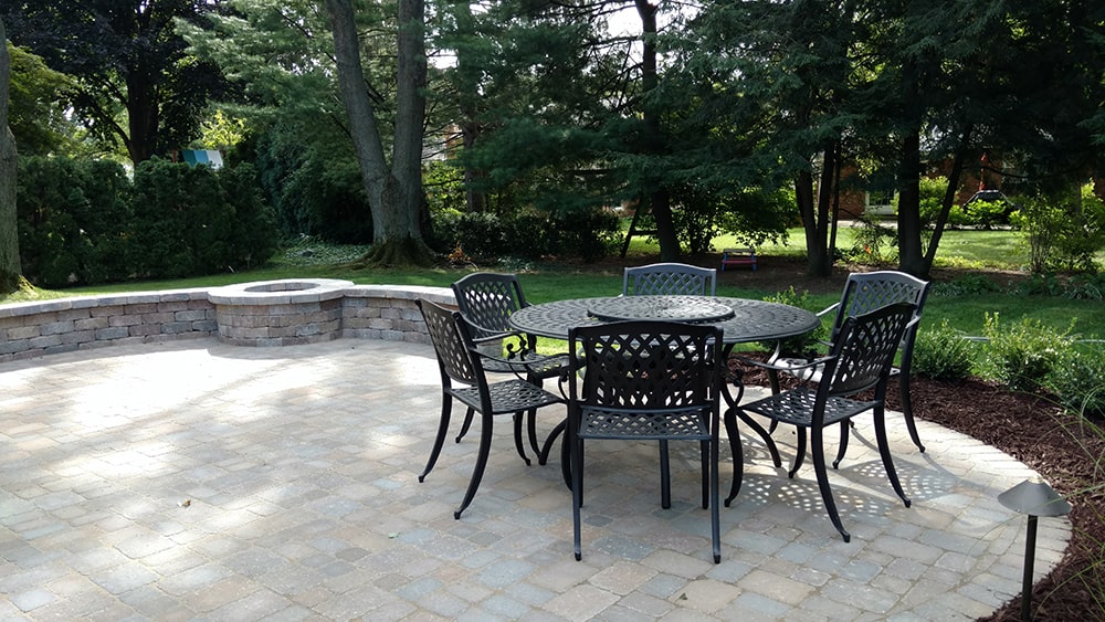 Image of a new backyard patio with fire pit, designed and constructed by BladeRunners Landscaping.