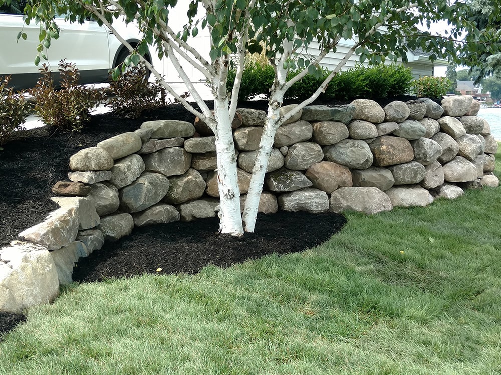 Image of a stone retaining wall, provided by BladeRunners Landscaping.