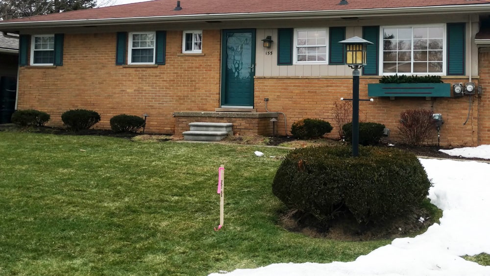 Before: Image of a dated home and landscaping.