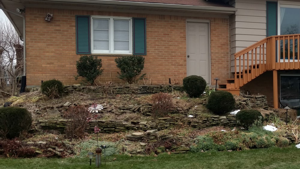 Before: Rear view of the same dated home and landscaping.