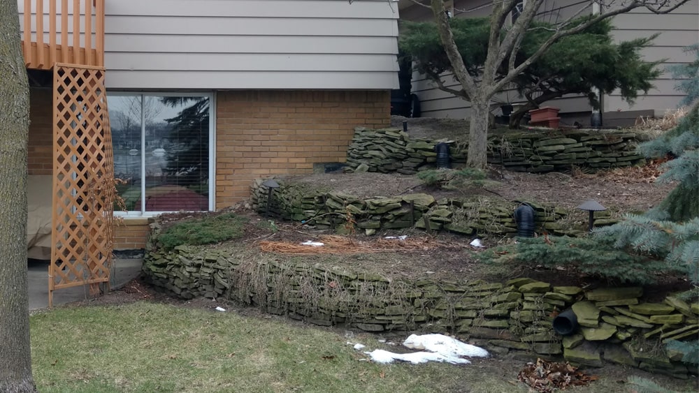 Before: Back corner view of the same dated home and landscaping.